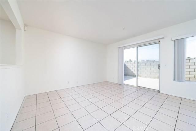 spare room with light tile patterned floors and a healthy amount of sunlight