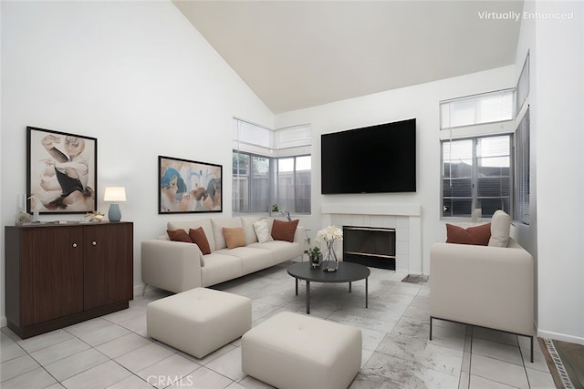 living room featuring high vaulted ceiling, baseboards, and a fireplace
