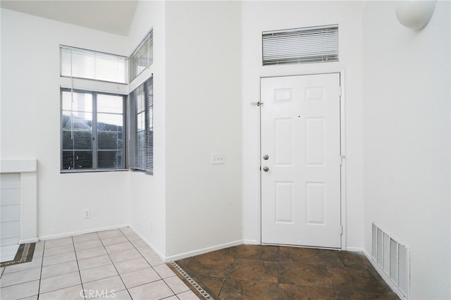 foyer featuring baseboards and visible vents