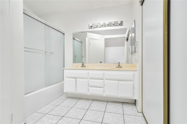 full bath featuring double vanity, tile patterned floors, a sink, and shower / bath combination with glass door