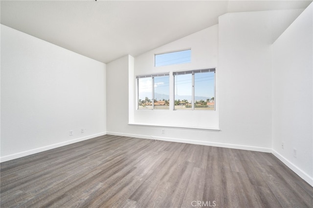 empty room with baseboards, dark wood-style floors, and high vaulted ceiling