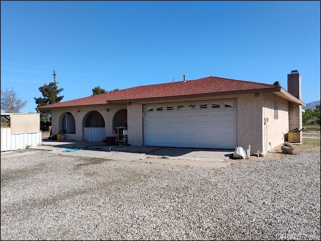 4077 Amador Rd, Phelan, CA 92371 - ranch-style home featuring a garage, driveway, a chimney, and stucco siding