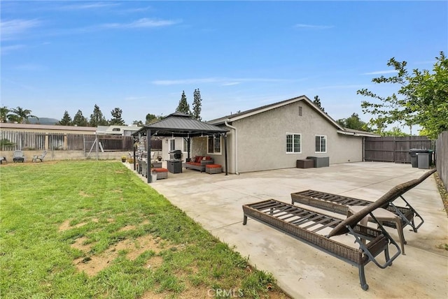 rear view of property featuring a gazebo, a patio area, and stucco siding