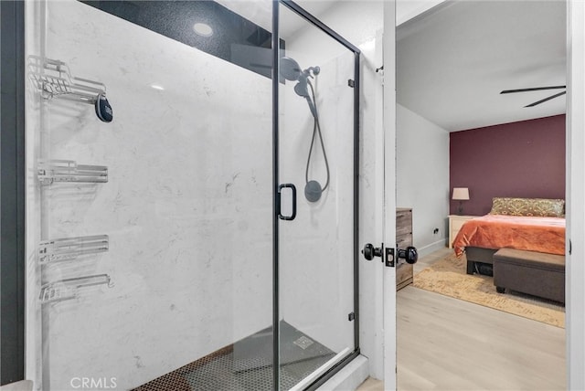 bathroom with ensuite bathroom, wood finished floors, and a shower stall