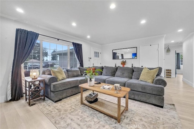 living area featuring light wood-style floors, healthy amount of natural light, recessed lighting, ornamental molding, and baseboards
