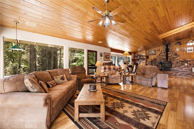 living room featuring wood-type flooring, a wood stove, ceiling fan, and wooden ceiling
