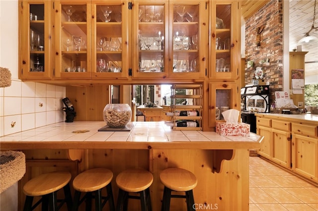 bar featuring light tile patterned floors, plenty of natural light, and backsplash