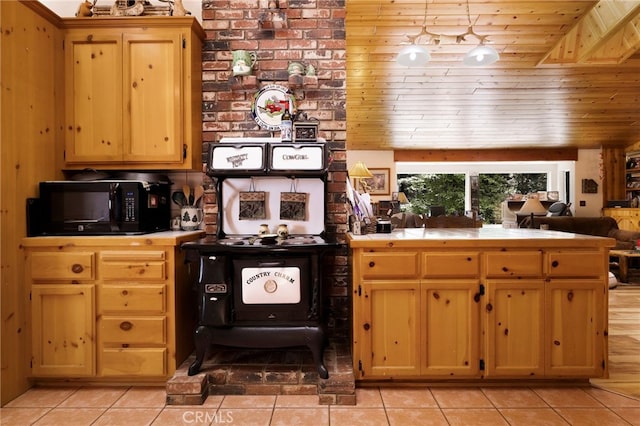 kitchen with tile counters, black microwave, wooden ceiling, and light tile patterned floors