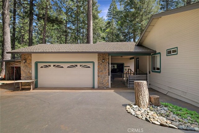 view of front of property with a garage, aphalt driveway, and stone siding