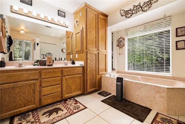 full bath with a sink, tile patterned flooring, a healthy amount of sunlight, and a garden tub