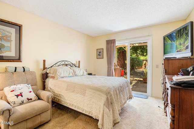 bedroom with access to outside, a textured ceiling, and light colored carpet
