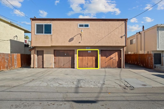 view of front of property featuring fence and stucco siding