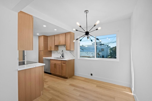 kitchen with stainless steel dishwasher, a sink, baseboards, a notable chandelier, and light wood-style flooring