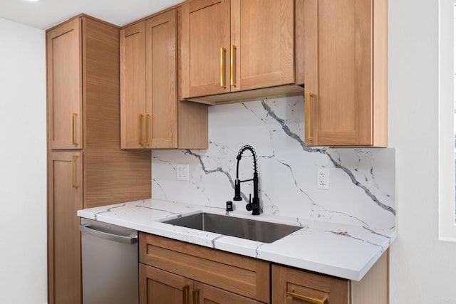 kitchen featuring light stone countertops, tasteful backsplash, a sink, and dishwasher