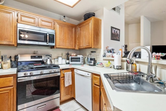 kitchen with light countertops, a sink, a toaster, and stainless steel appliances
