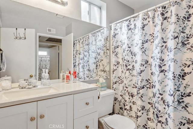 bathroom with toilet, visible vents, curtained shower, and vanity