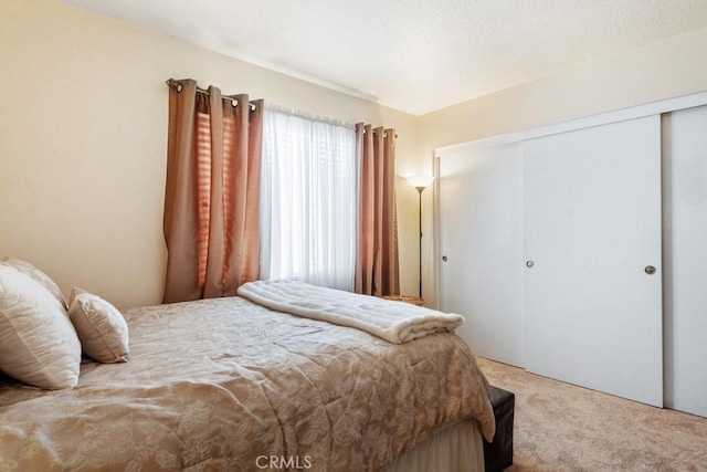 bedroom featuring light carpet and a closet