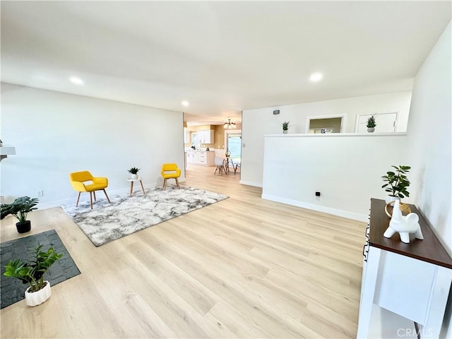 living area featuring baseboards, recessed lighting, and wood finished floors