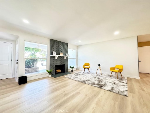 sitting room featuring recessed lighting, baseboards, a brick fireplace, and light wood-type flooring