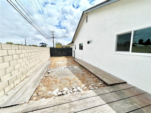 view of side of property featuring a fenced backyard and stucco siding