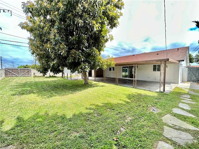 view of yard with a gate, a patio area, and a fenced backyard