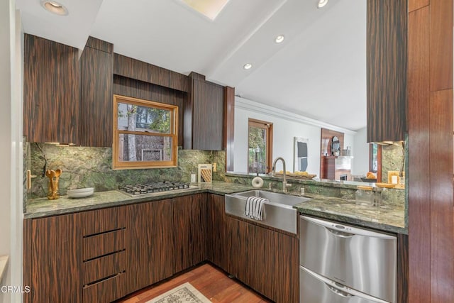 kitchen featuring a sink, stainless steel appliances, light wood finished floors, and a wealth of natural light