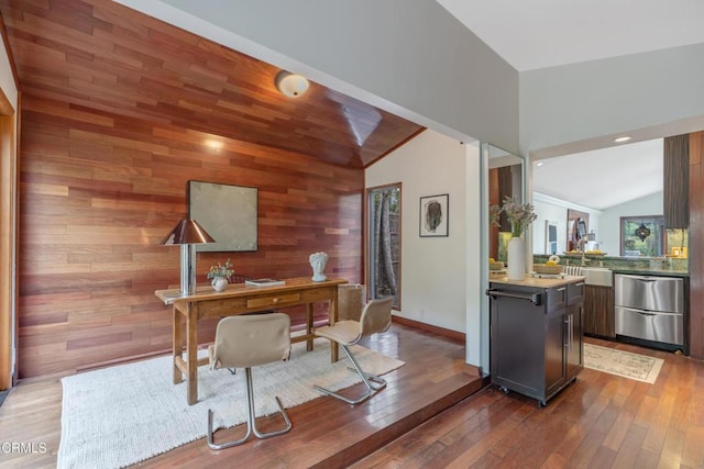 office with a sink, high vaulted ceiling, wood walls, baseboards, and hardwood / wood-style flooring