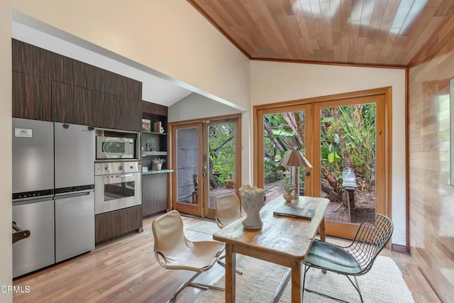 dining space featuring vaulted ceiling, plenty of natural light, and french doors