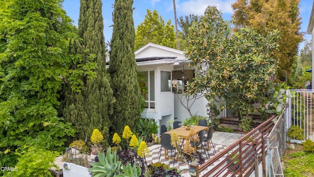 view of property exterior featuring a patio, outdoor dining area, and stucco siding