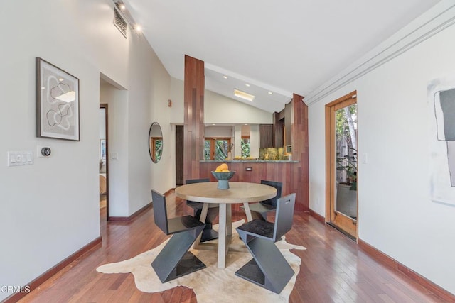 dining space featuring visible vents, wood finished floors, baseboards, recessed lighting, and vaulted ceiling