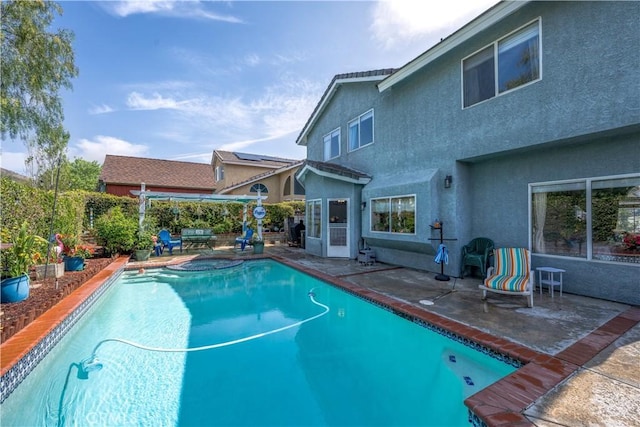 view of swimming pool featuring fence, a patio, and a pool with connected hot tub