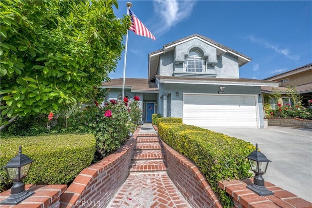 traditional-style house featuring a garage, stucco siding, and driveway