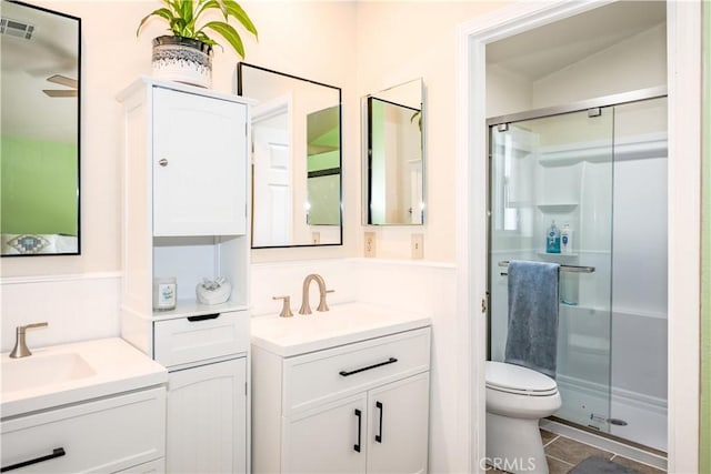 bathroom featuring two vanities, a shower stall, and a sink
