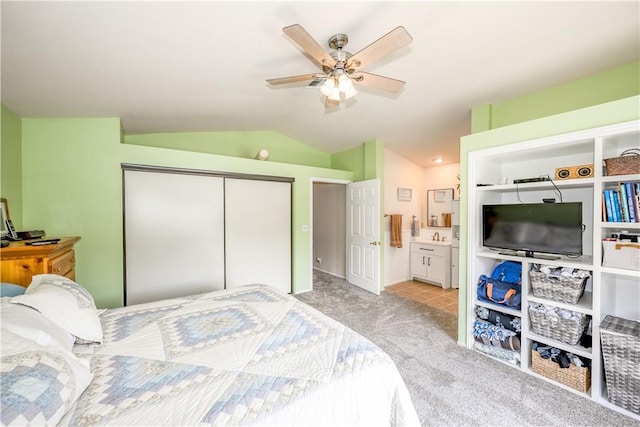 bedroom featuring a closet, lofted ceiling, ceiling fan, connected bathroom, and carpet