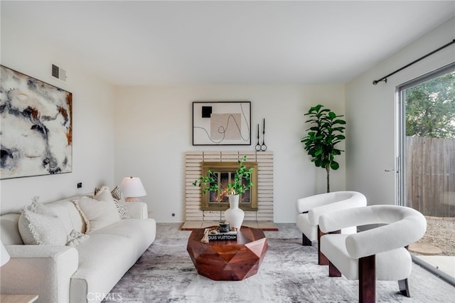 living area featuring carpet floors, visible vents, and a fireplace
