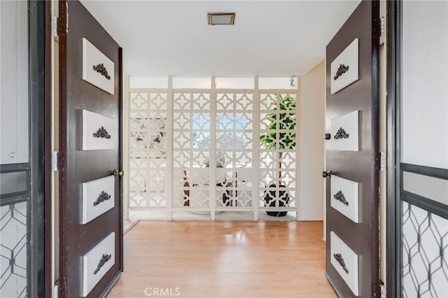 foyer entrance featuring floor to ceiling windows and wood finished floors