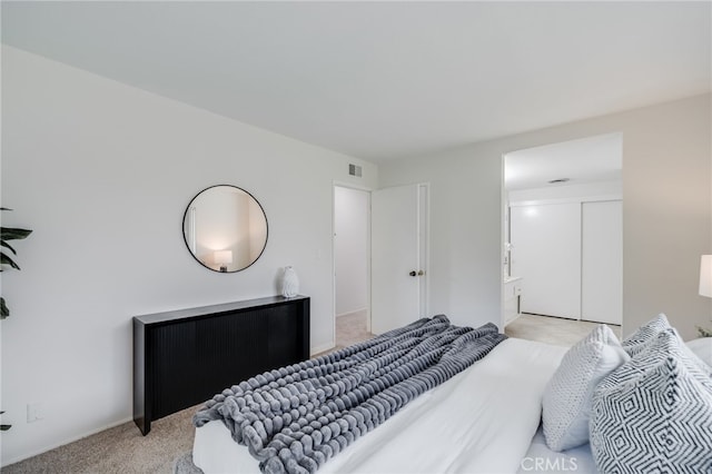 bedroom with visible vents and light carpet