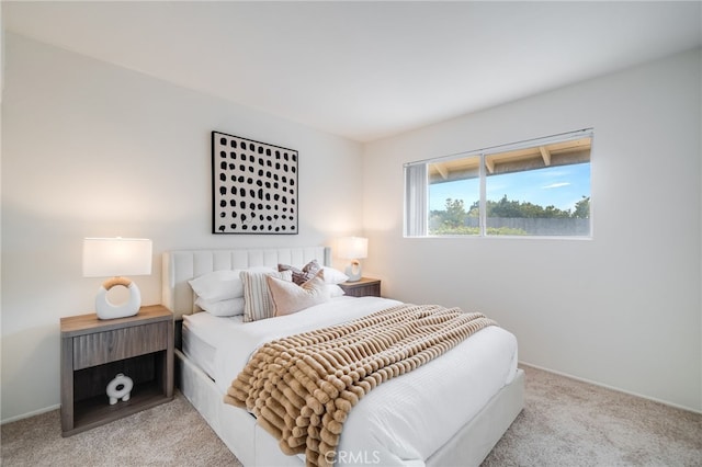 bedroom featuring baseboards and light carpet