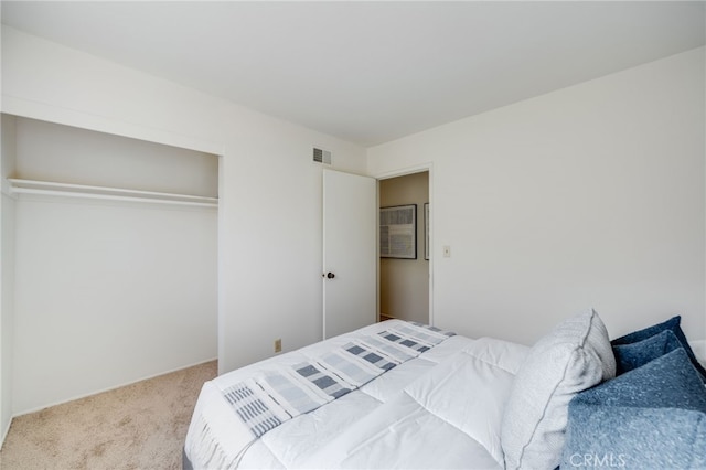 bedroom with carpet flooring, visible vents, and a closet