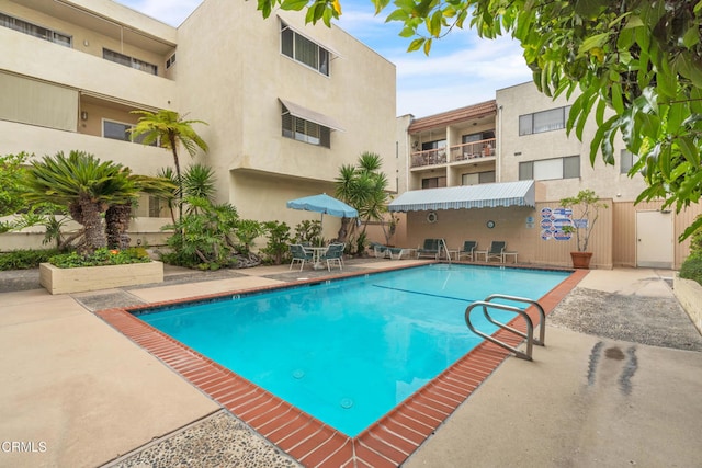 community pool featuring outdoor dining area and a patio area
