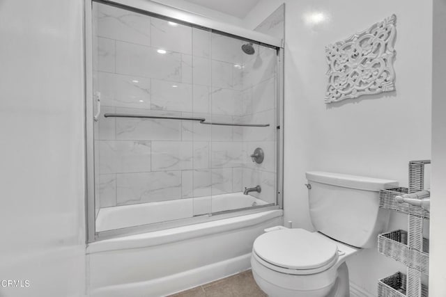 bathroom featuring combined bath / shower with glass door and toilet