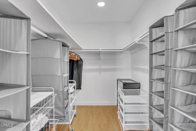 walk in closet with wood finished floors