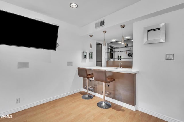bar featuring wet bar, visible vents, wood finished floors, baseboards, and recessed lighting