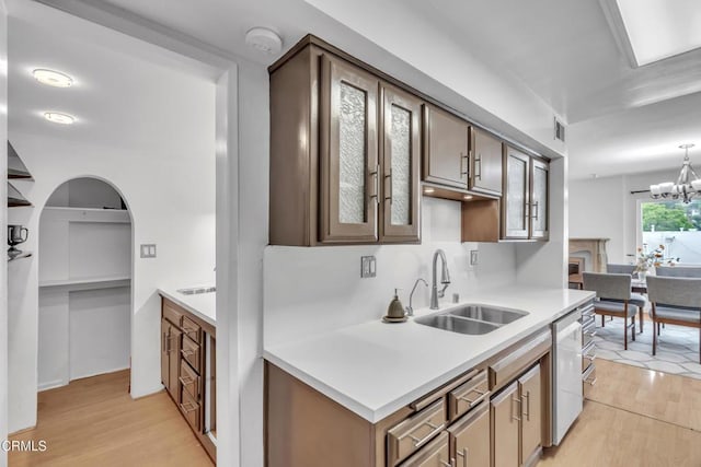 kitchen featuring dishwasher, visible vents, a sink, and light wood-type flooring