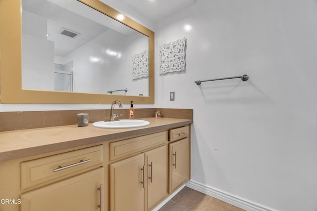 full bathroom featuring a shower with shower door, vanity, tile patterned floors, baseboards, and visible vents