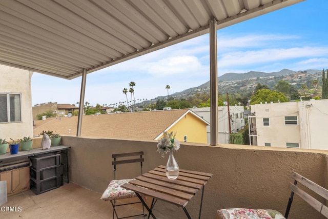 view of patio featuring a mountain view, a balcony, and a residential view