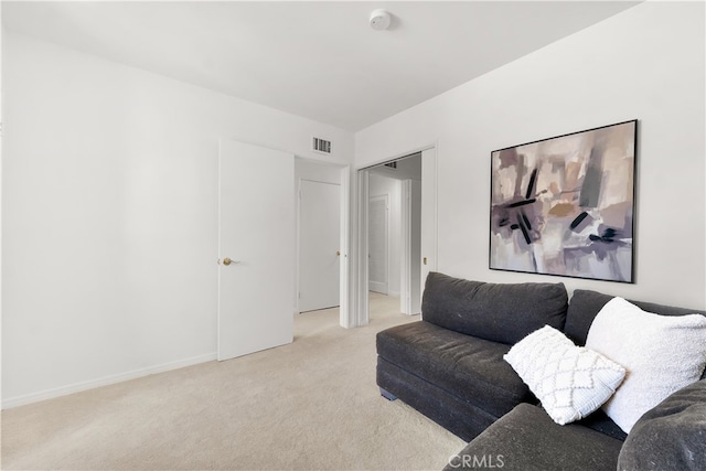 living room featuring visible vents, baseboards, and light carpet