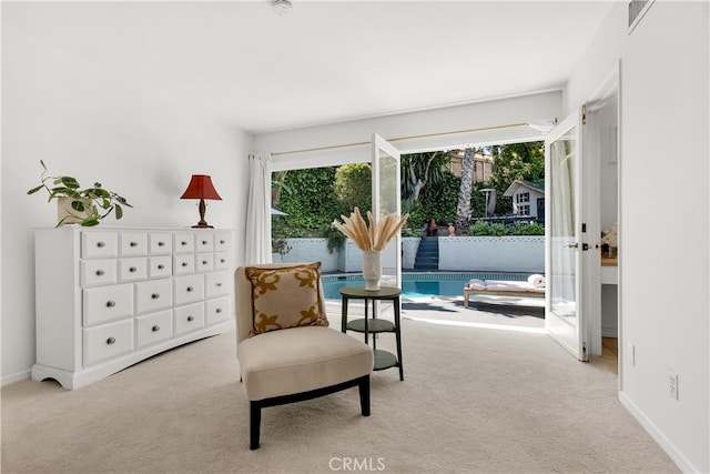 sitting room featuring carpet floors, baseboards, and visible vents