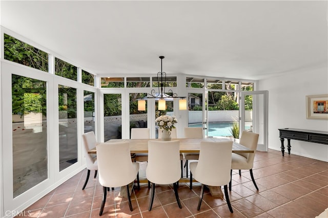 tiled dining room featuring baseboards and a chandelier