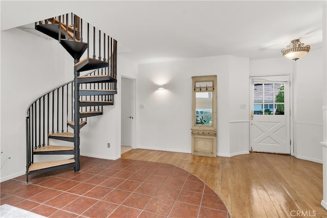 entrance foyer featuring stairs, baseboards, and wood finished floors